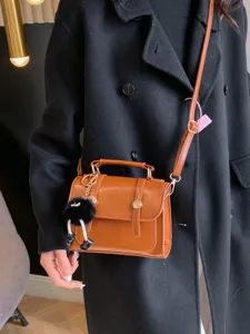 Sac bandoulière marron en cuir PU style collège avec poignée et charmant pendentif en peluche.