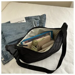 Black quilted nylon crossbody bag interior capacity detail showing spacious storage for daily items.