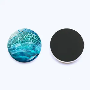 Close up detail of round ocean wave glass fridge magnet with soft magnetic backing for whiteboards.