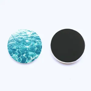 Detail shot of round ocean water wave glass fridge magnet with crystal front and back.