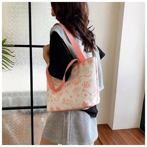 Casual women's canvas tote bag featuring stylish orange graffiti print for daily commuting.