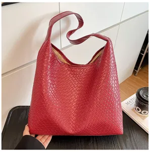 Detail shot of wine red woven leather shoulder bag showcasing intricate texture and craftsmanship.