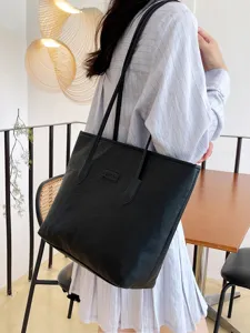 Black embossed tote bag for women, large capacity shoulder bag, casual commuter handbag.