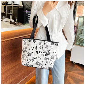 Simple white canvas tote bag for women, featuring trendy black graffiti prints and large capacity.