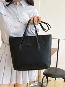 Black embossed tote bag detail, featuring durable material and large daily capacity.