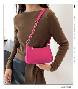Elegante borsa a tracolla rosa da donna con catena chic e texture alla moda e casual.