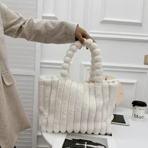 Detailaufnahme der stilvollen weißen Plüsch-Tasche mit einzigartigem Kugel-Griff-Design.