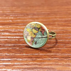 Gros plan detaille d un anneau en bronze vintage avec motif carte du monde en verre cabochon