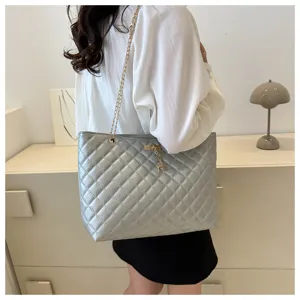 Detailansicht der gesteppten Umhängetasche mit schicker Kette und süßem Hirsch-Anhänger.