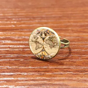 Bague vintage en bronze avec motif de carte du monde ancienne, vue de détail rapprochée.