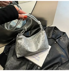 Silver snakeskin pattern detail of trendy underarm shoulder bag with knot handle.