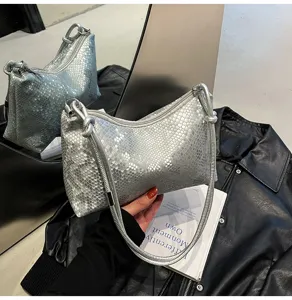 Detailed close-up of a stylish silver snake-pattern underarm shoulder bag with knotted strap.