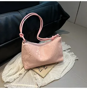Detailed view of the pink faux snakeskin underarm shoulder bag with chic knotted strap.