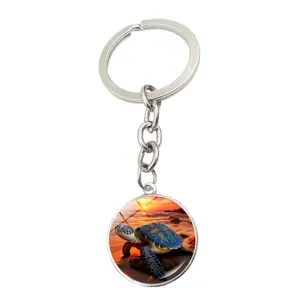 Close-up detail view of the sea turtle glass cabochon pendant on the metal keychain ring.