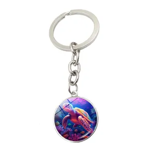 Close-up detail of the colorful sea turtle glass cabochon pendant on the metal keychain.