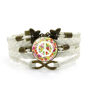 Bracciale in pelle intrecciata multistrato vintage con ciondolo segno pace floreale e farfalle.