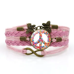 Bracciale in pelle rosa intrecciato multistrato con ciondoli vintage a farfalla e segno di pace.