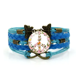 Primo piano dettagliato del bracciale in pelle intrecciata blu multistrato con ciondoli in bronzo.