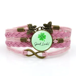 Bracciale in pelle intrecciata rosa con ciondolo in vetro trifoglio e dettagli farfalla vintage.