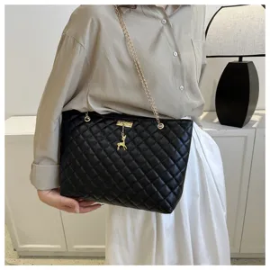 Detailansicht der schwarzen gesteppten Schultertasche mit goldener Kette und Hirsch-Anhänger.
