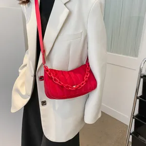 Detailed shot of the red quilted shoulder bag with chunky chain strap and stylish oxford fabric.