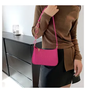 Elegante borsa a spalla rosa in feltro da donna con texture pietra e tracolla a catena.