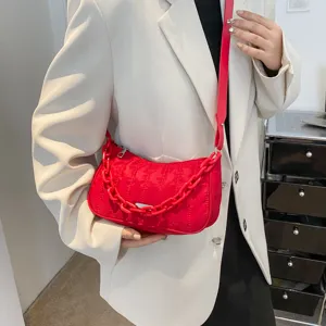 Red quilted nylon shoulder bag with chunky chain strap and zip closure for women daily use.