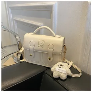 Retro PU leather mini crossbody bag for women, cute vintage satchel with plush pendant.