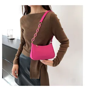 Borsa a spalla rosa con motivo coccodrillo, foto di dettaglio per look alla moda.