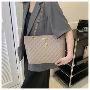 Beige gesteppte Schulter-Totetasche mit Metallkettengurt und süßem Hirsch-Anhänger.