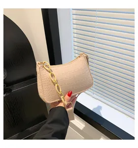 Vista dettagliata della borsa sottoascellare in feltro beige con motivo pietra e catena.