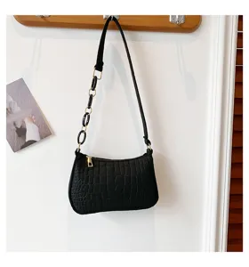 Vista dettagliata della borsa a spalla nera con motivo pietra, catena chic e chiusura lampo.