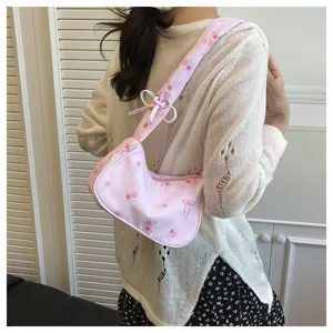 Detail shot of pink floral shoulder bag with cute bow and strap design for sweet style.