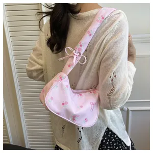 Detailed view of sweet pink floral canvas shoulder bag featuring cute bow tie strap design.