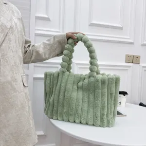 Nahaufnahme des flauschigen grünen Plüsch-Tragetasche mit einzigartigem Kugeltaschengriff.