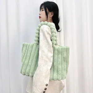 Detailaufnahme einer flauschigen grünen Tote-Bag mit Streifen und weicher Plüschtextur.