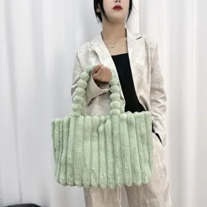 Detailaufnahme der flauschigen hellgrünen Handtasche mit weicher Plüschtextur für den Winterstil.