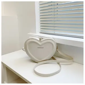 White heart-shaped crossbody bag detail showing the smooth surface and metal zipper closure.