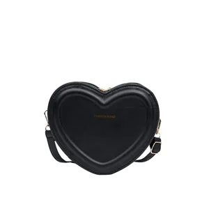 Detailed close-up of the black heart-shaped crossbody bag featuring smooth PU leather and cute design.