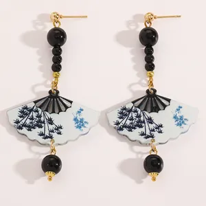 Detailed macro view of Chinese style fan earrings featuring blue ink bamboo patterns