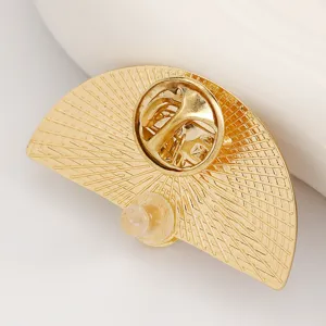 Close-up of golden fan-shaped brooch back with butterfly clutch pin