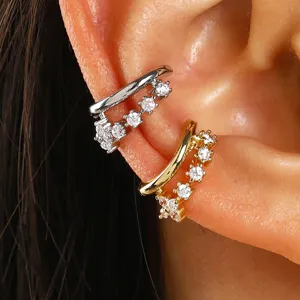 Detailed view of gold and silver zircon ear cuffs worn on the ear cartilage without piercing.