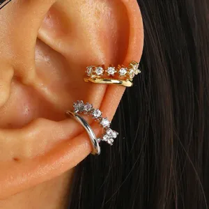 Close-up detail of sparkling multi-layer gold and silver zircon ear cuffs on ear
