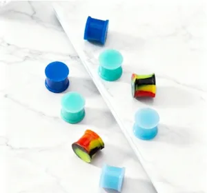 Silicone ear plugs detail shot showing various colorful solid gauges on a marble background.