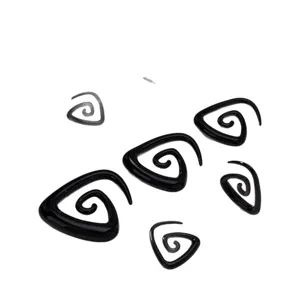 Close-up detail of black acrylic spiral and triangle ear expansion piercing jewelry set.