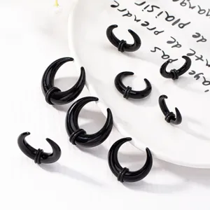 Detailed close-up view of black acrylic horn ear tapers and stretching plugs with rubber rings.