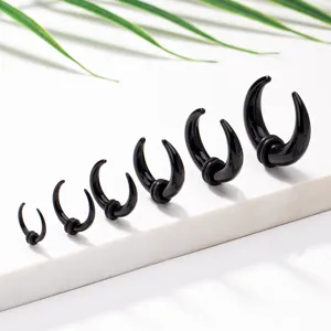 Close-up detail of graduated black horn ear stretchers with o-rings displayed on clean white.