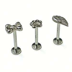 Piercing labret in titanio con design a fiocco, zampa e ala per gioielli corporei.