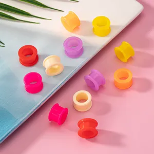 Colorful silicone ear tunnels and plugs detail shot, showing hollow pulley design in various solid colors.