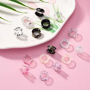 Nahaufnahme bunter Acryl-Ohrdehners mit Farbspritzern für Piercing und Ohrschmuck.